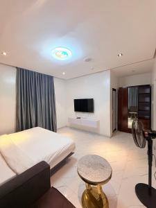 a hotel room with a bed and a flat screen tv at SereneHiz Shelters in Enugu