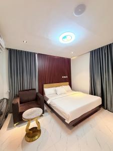 a bedroom with a bed and a chair at SereneHiz Shelters in Enugu