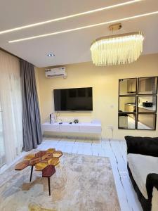 a living room with a couch and a chandelier at SereneHiz Shelters in Enugu +1 photo
