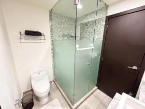 a bathroom with a toilet and a glass shower at Departamento de lujo en Col Americana con alberca in Guadalajara +22 photos