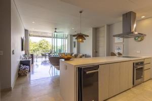 a kitchen with a counter top and a living room at 3 Bedroom apt with jacuzzi in Baru in Cartagena de Indias +41 photos
