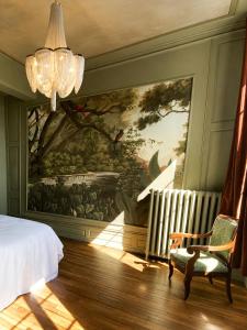 a bedroom with a large painting on the wall at La Villa Du Temple - Climatisation in Auxerre +26 photos