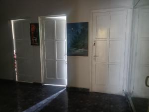 a hallway with two white doors and a painting on the wall at Nazareth in Lima