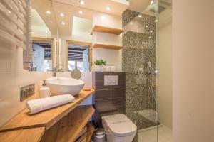 La salle de bains est pourvue d'un lavabo et d'une douche. dans l'établissement Apartamenty Polana Sywarne Zakopane, à Kościelisko