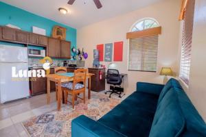 a living room with a blue couch and a kitchen at BELIZE TROPICAL DREAM VILLAS in San Pedro