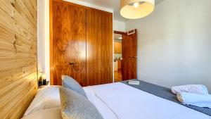 a bedroom with a white bed and a wooden headboard at Molina Molinísimo in La Molina