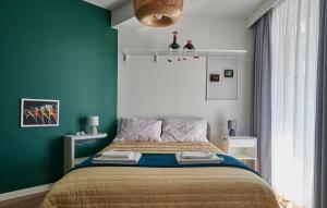 a bedroom with a bed with a green wall at Apartament Kaskady75 in Łańcut