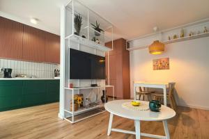 a living room with a table and a kitchen at Apartament Kaskady75 in Łańcut