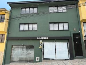 a green building with windows on a street at Casa Vernazza in Manizales
