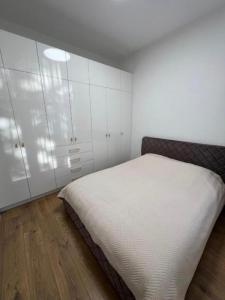 a bedroom with a bed and white cabinets at Modern apartment in Klaipėda +1 photo
