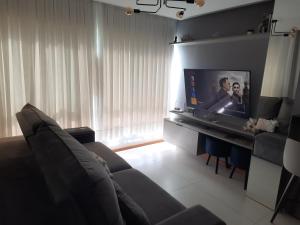 a living room with a couch and a flat screen tv at Meu lar na Serra Gaúcha in Nova Petrópolis