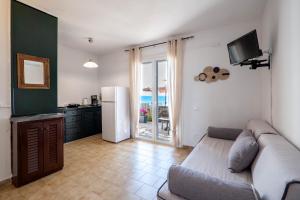 a living room with a couch and a refrigerator at Corfu Glyfada Beach Apartment 24 in Glyfada