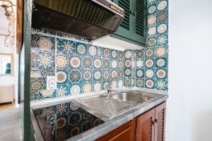a kitchen with a sink and a tiled wall at Corfu Glyfada Beach Apartment 24 in Glyfada +35 photos