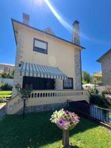 ein Haus mit Balkon und Blumen im Garten in der Unterkunft La Almendrina Casa Rural in Villafranca del Bierzo