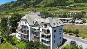 eine Luftaufnahme eines Gebäudes mit einem Berg in der Unterkunft Typically Swiss Hotel Altana in Scuol + 8 Fotos