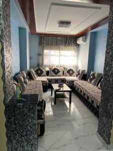 a living room with couches and a coffee table at Zaio in Nador