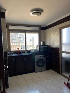 a kitchen with a sink and a washing machine at Zaio in Nador