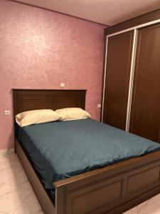 a bedroom with a bed in a room with pink walls at Zaio in Nador