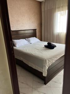 a bedroom with a bed with a hat on it at Zaio in Nador +1 photo