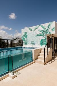 a building with a swimming pool in front of a mural at Hotel Zendero Tulum in Tulum