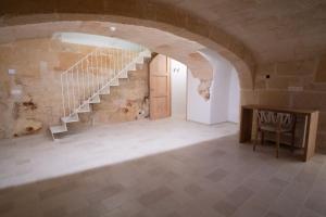 a room with a staircase in a stone building at Hotel Cas Ferrer Monjo in Ciutadella