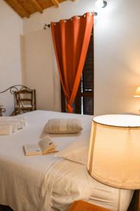 a bedroom with a bed with a book and a lamp at CASA MILENA in Settimo San Pietro