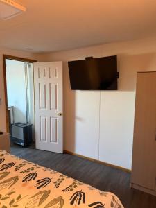 a bedroom with a bed and a flat screen tv at Casa monje Patagonia in Puerto Natales