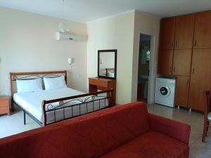 a bedroom with a bed and a red couch at Armonia Nakas in Yénion +37 photos