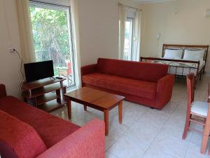 a living room with two red couches and a table at Armonia Nakas in Yénion