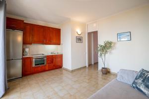 a kitchen with wooden cabinets and stainless steel appliances at Corfu Glyfada Beach Apartment 40 in Glyfada