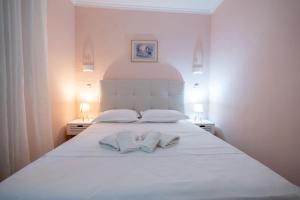 a white bed with two white towels on it at Corfu Glyfada Beach Apartment 40 in Glyfada