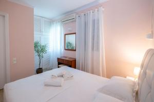 a white bedroom with a bed and a window at Corfu Glyfada Beach Apartment 40 in Glyfada