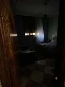 a dark room with a bed and a window at MEFTAH lkhir hay nour in Safi