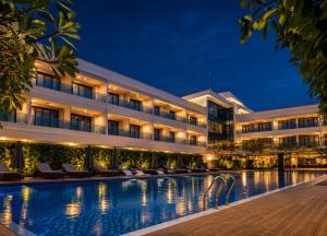 a hotel with a swimming pool at night at Kiranshree Grand in Guwahati