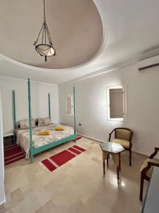 a bedroom with a green bed and a chair at maison rachid in El Guecheïne