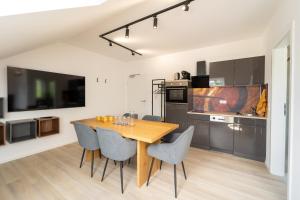 a kitchen and dining room with a wooden table and chairs at Glückszeit Apartments Gießen in Gießen +13 photos