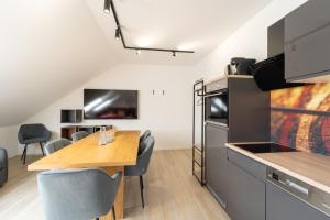 a kitchen with a wooden table and a dining room at Glückszeit Apartments Gießen in Gießen