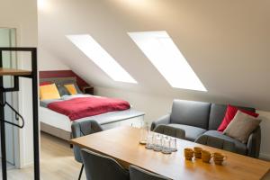 a living room with a table and a bed at Glückszeit Apartments Gießen in Gießen