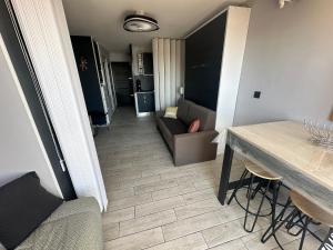 a living room with a couch and a table at L'Acropole in Cap d'Agde +10 photos