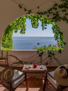 a room with a table and chairs and a view of the ocean at Hotel Carasco in Lipari