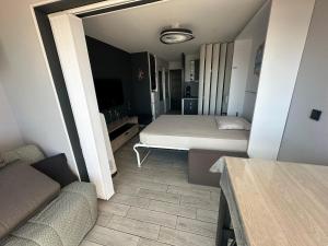 a small room with a bed and a couch at L'Acropole in Cap d'Agde
