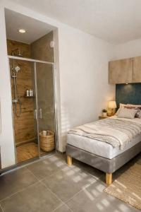 a bedroom with a bed and a glass shower at Studio U Karolíny Nová Pec in Nová Pec