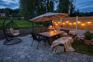 a patio with a table with an umbrella and a bench at Studio U Karolíny Nová Pec in Nová Pec