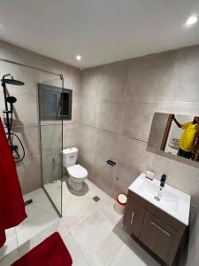 a bathroom with a toilet and a shower and a sink at Residence LOUNA in Dakar