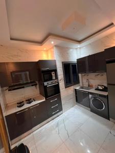 a large kitchen with black and white appliances at Residence LOUNA in Dakar