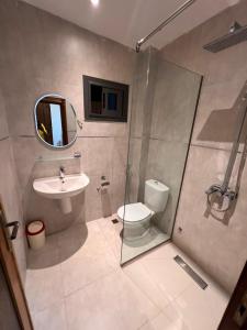 a bathroom with a sink and a toilet and a mirror at Residence LOUNA in Dakar
