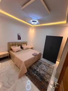a bedroom with a large bed and a tv at Residence LOUNA in Dakar