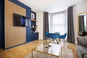 a living room with a couch and a table at Lamara Deluxe Apartments, Liverpool in Liverpool