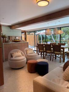 a living room with couches and chairs and a table at Refúgio com Pé na Areia in Mata de Sao Joao