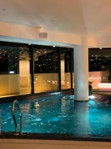 a swimming pool in a building with a view of the city at Hotel Bulevar Mostar in Mostar